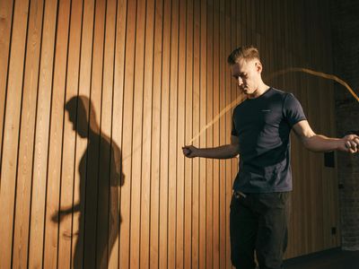 Person hands holding a jump rope in a dark room